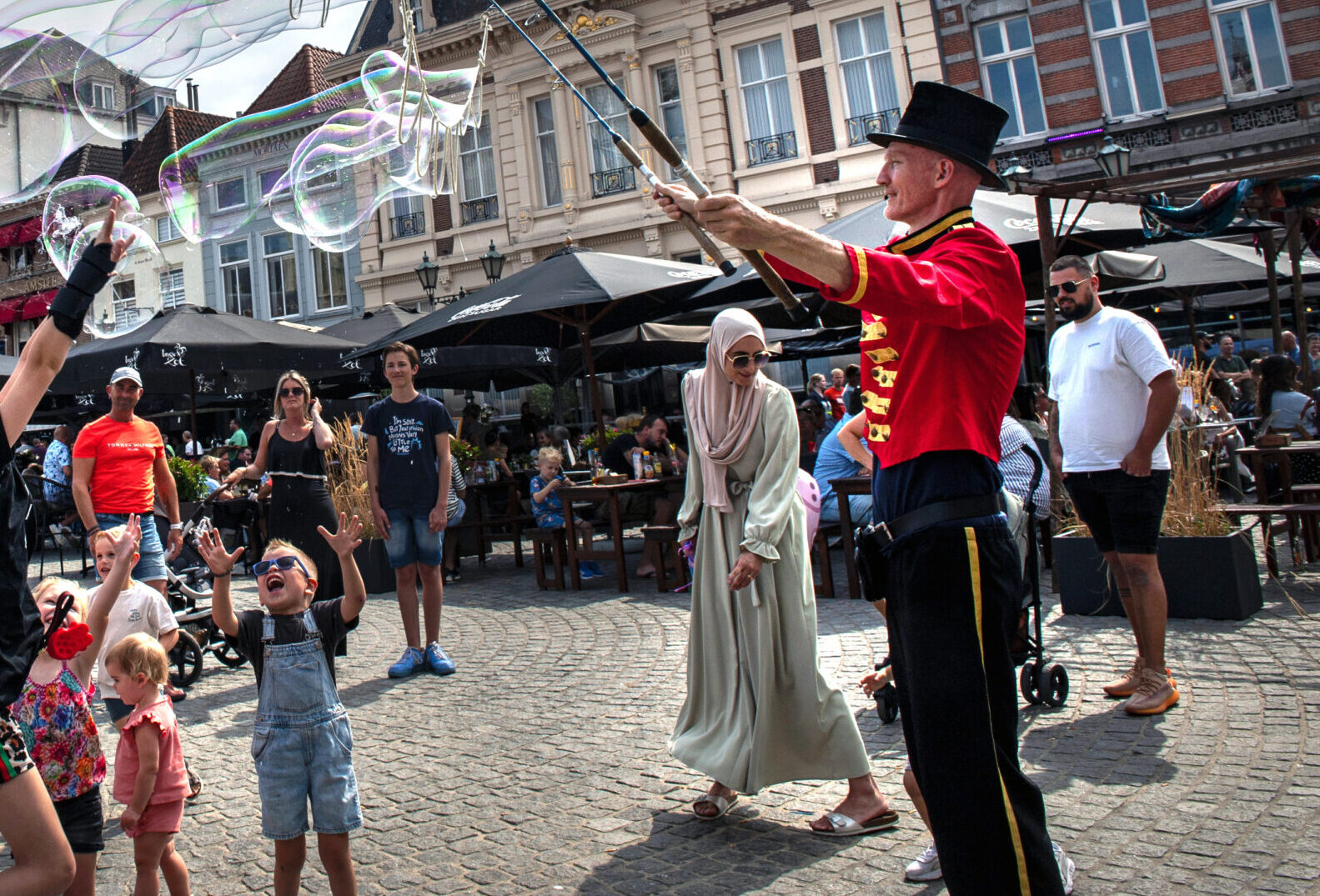 Kinderen spelen met reuzenzeepbellen op plein - Bergen op Zoom
