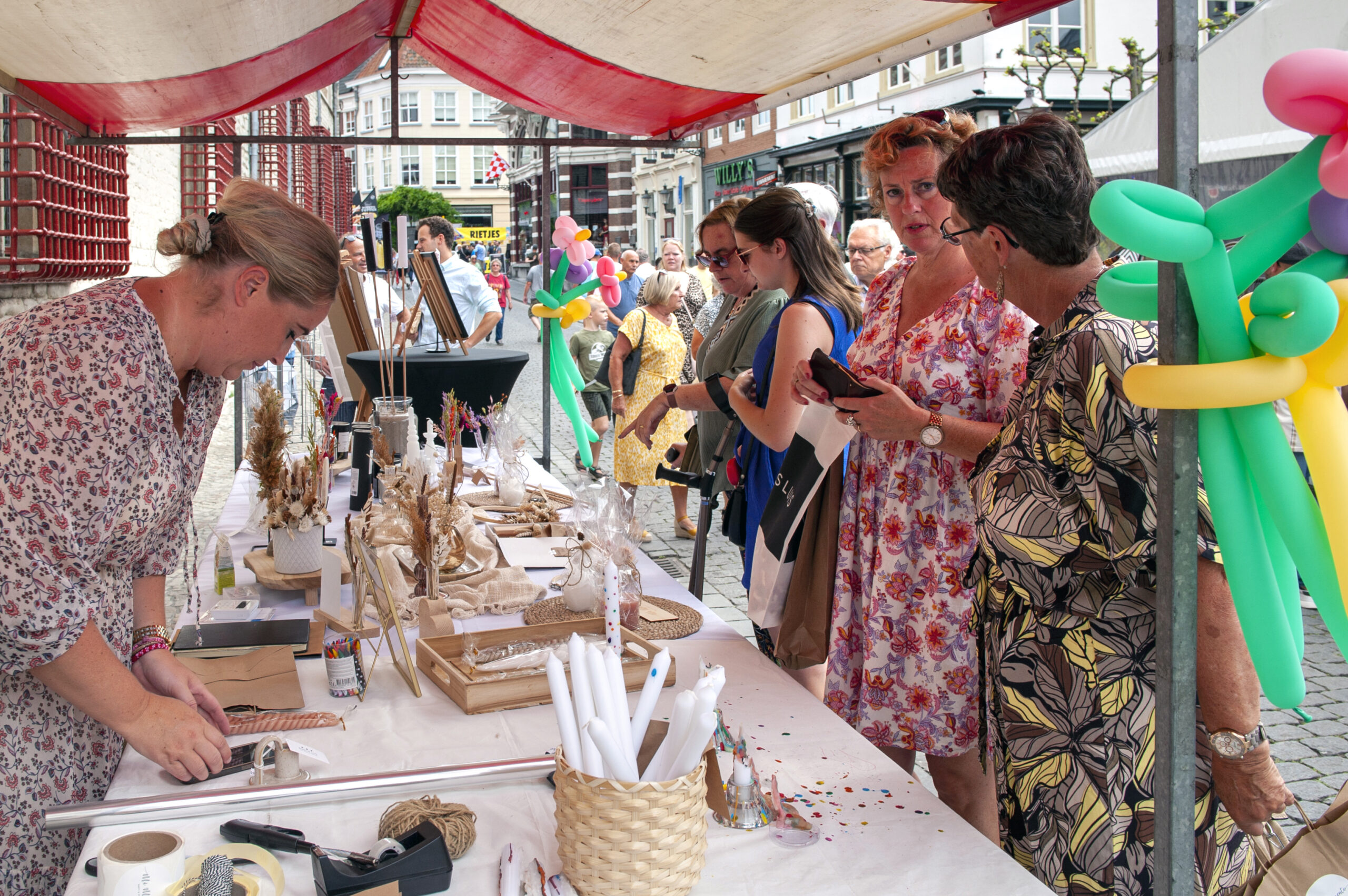 Mensen bekijken handgemaakte producten op straatmarkt