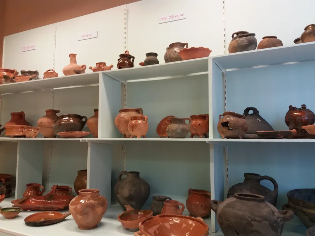 Oude aardewerken potten tentoongesteld op planken