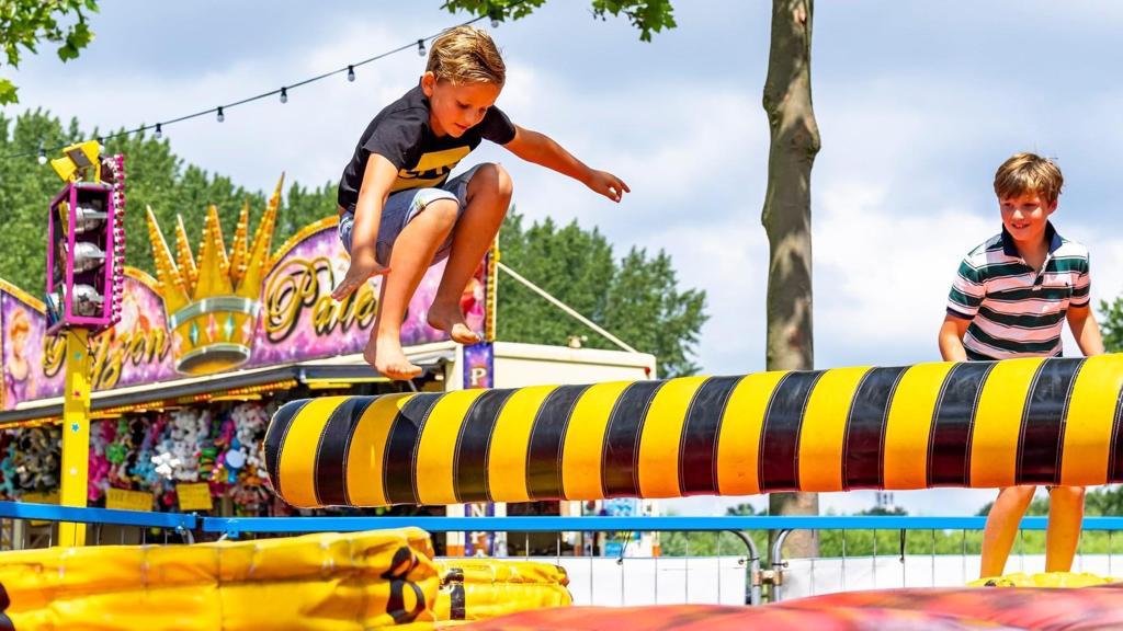 Twee jongens spelen op kermisattractie in park