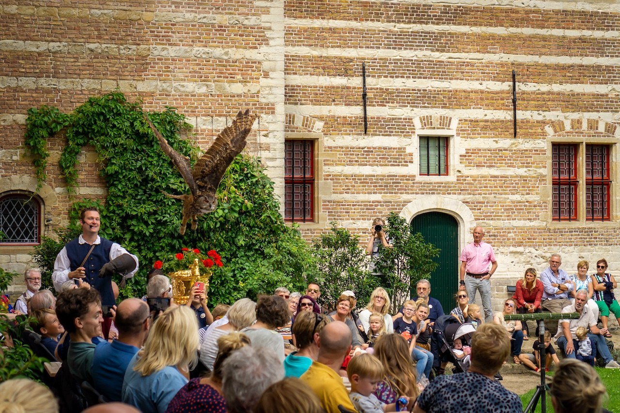 People watch a birds of prey show in the historic Markiezenhof garden