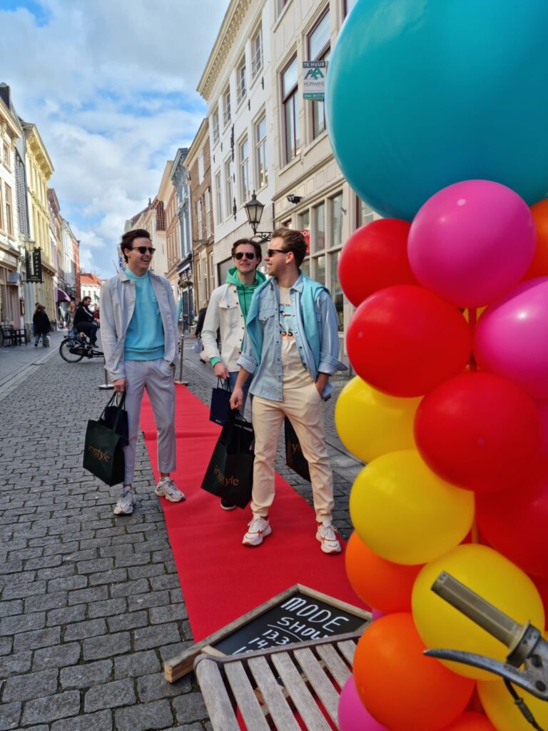 Mensen winkelen tijdens een kleurrijke modeshow evenement