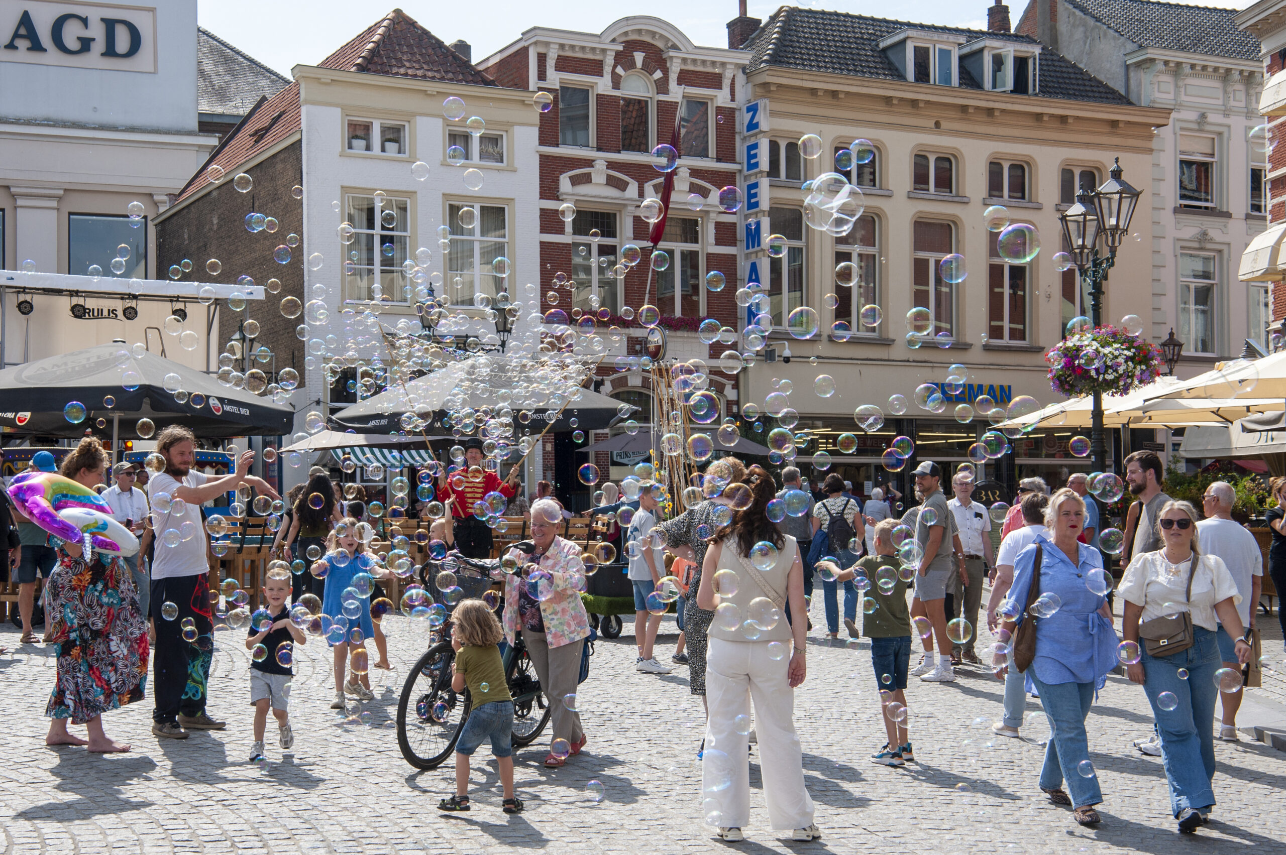 Drukke marktplaats met mensen en bellen - Bergen op Zoom