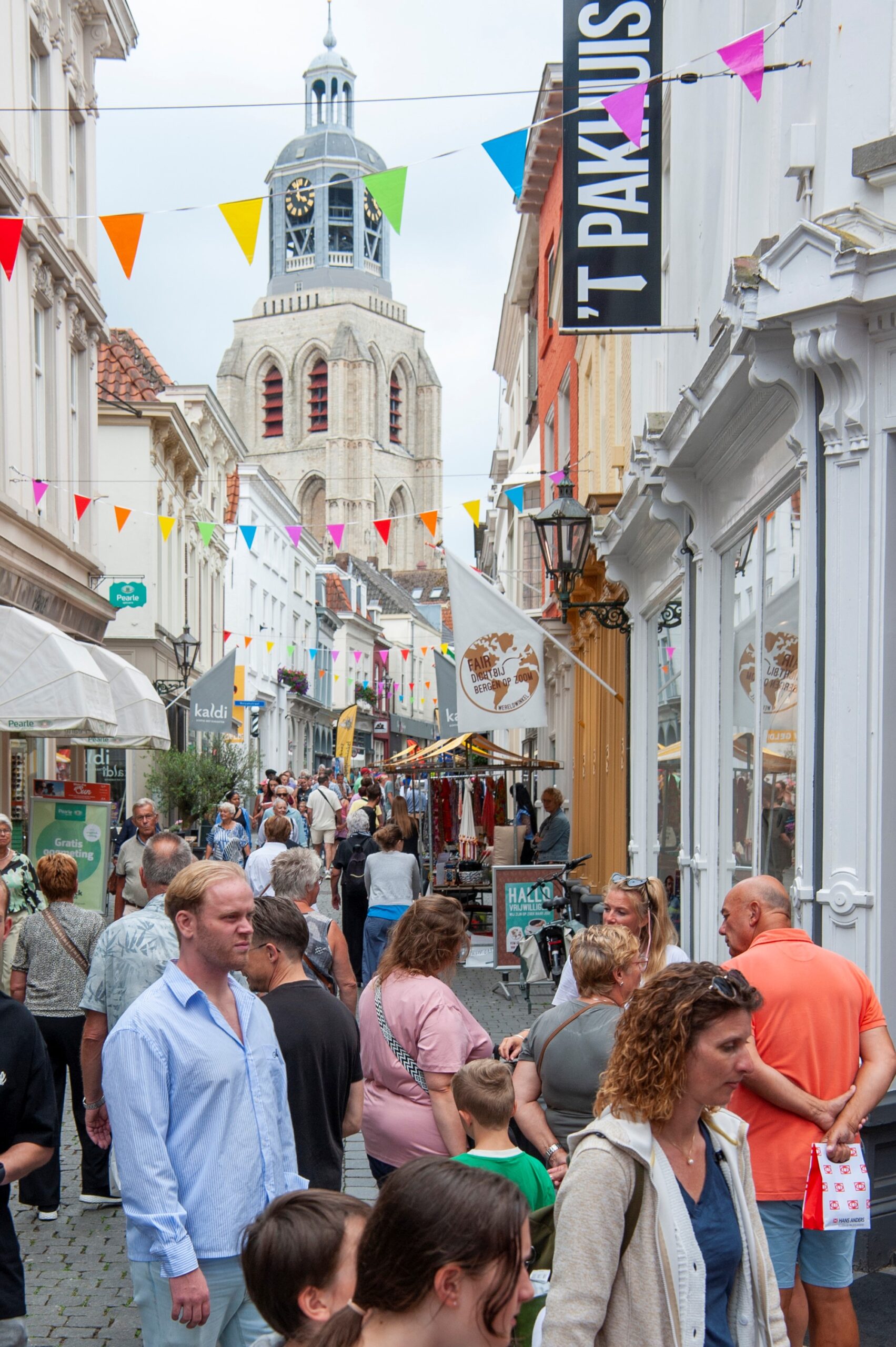 Drukke winkelstraat met kerkklok in de verte - Bergen op Zoom