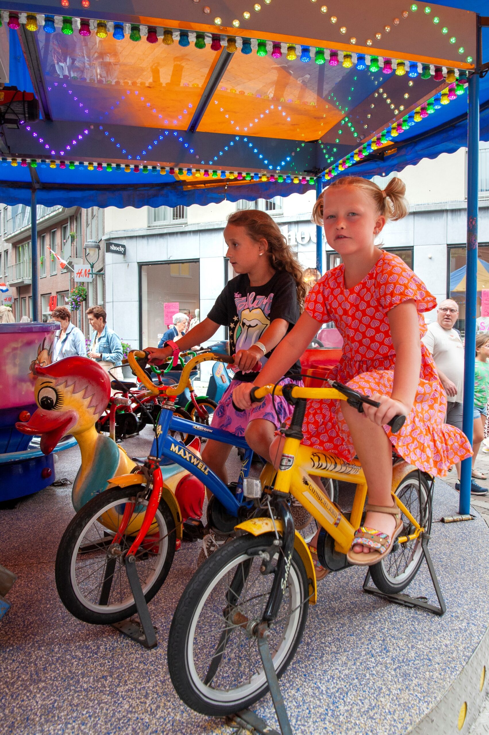 Kinderen op draaimolen fietsen kermis plezier - Bergen op Zoom