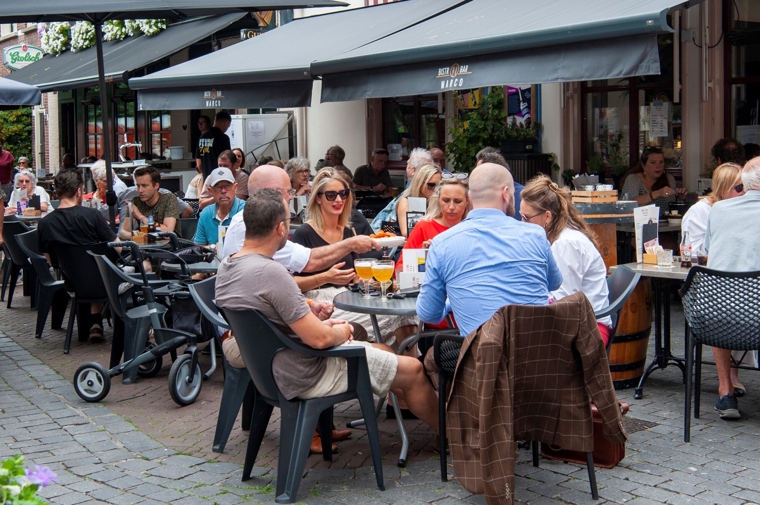 Mensen genieten op een terras in de zon - Bergen op Zoom