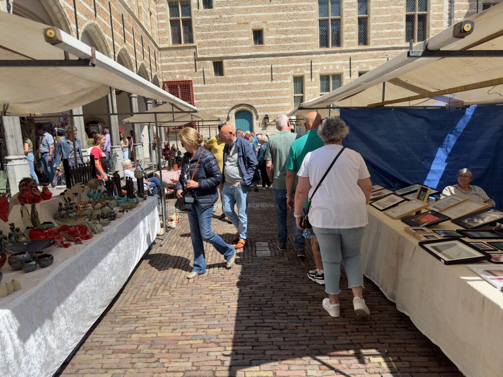 Mensen verkennen kraampjes op straatmarkt - Bergen op Zoom